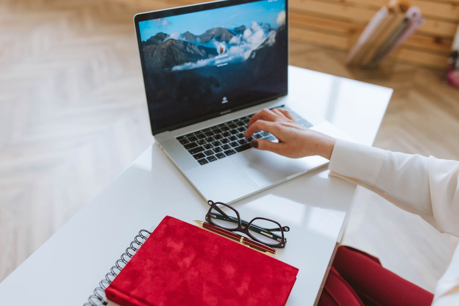 Person reviewing paperwork beside a laptop